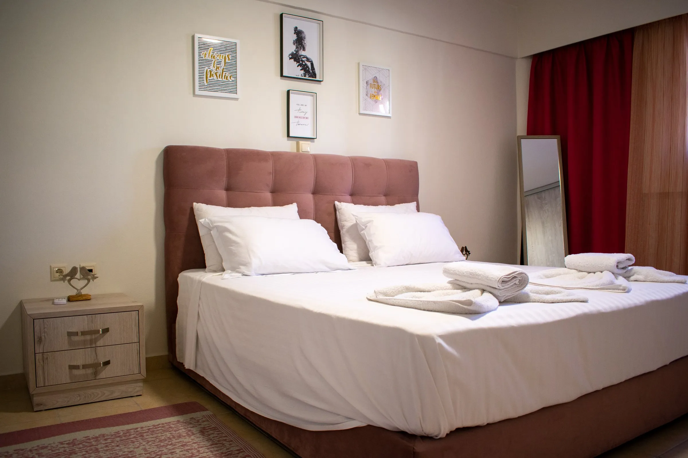 Double bed with towels and framed prints